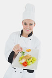 Female chef holding plate of healthy food