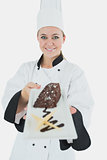 Young female chef offering pastry