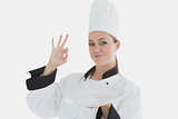 Chef with an empty plate gesturing ok sign