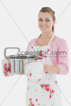 Maid in apron holding kitchen utensil