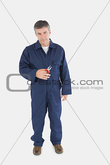 Mature technician holding pliers