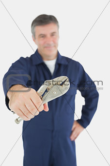 Male mechanic holding vise grip