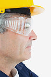 Technician wearing protective eye wear and hardhad looking away