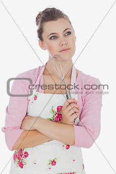 Thoughtful maid holding wire whisk