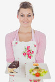 Beautiful maid holding plates of pastry and healthy food