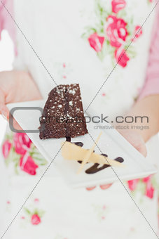 Woman holding plate of delicious pastry