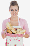 Happy young woman holding bread basket