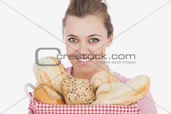 Happy young woman with basket full of breads