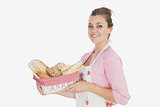 Young woman holding basket full of breads