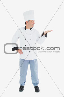 Mature chef looking at invisible product