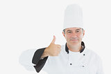 Mature chef in uniform showing thumbs up sign