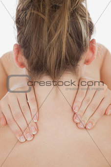 Young woman massaging neck