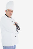 Mature chef in uniform standing with arms crossed