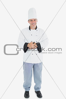 Happy male chef holding tongs