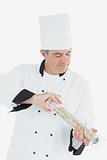 Mature chef using pepper mill