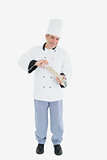 Happy chef using pepper mill