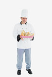 Male chef holding bread basket