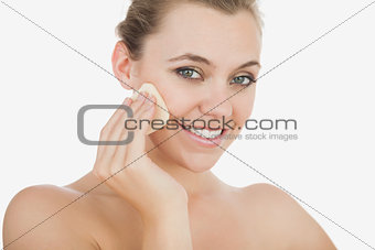 Young woman using powder puff