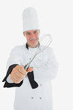 Male chef showing wire whisk