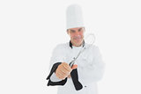 Mature chef holding wire whisk