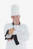 Mature chef showing wire whisk