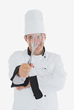 Happy male chef holding wire whisk