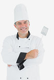Man in chef uniform holding spatula