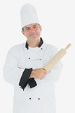 Man in chef uniform holding rolling pin