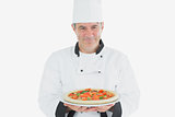 Male chef holding pizza