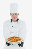 Man in chef uniform holding pizza