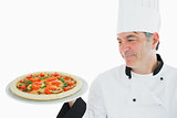 Happy chef looking at pizza