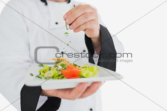 Male chef garnishing fresh prepared meal