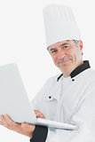 Happy male chef using laptop