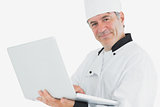 Male chef using laptop smiling