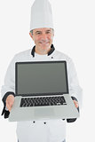 Happy male chef shwoing laptop