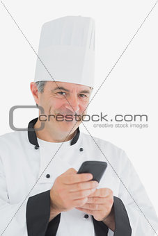 Portrait of happy chef holding cell phone