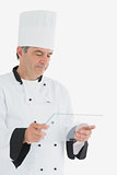 Male chef looking at glass tablet