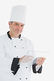 Portrait of happy chef using glass tablet