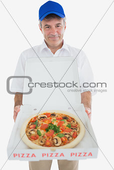 Mature delivery man holding pizza