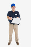 Mature delivery person holding out clipboard