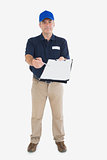 Mature delivery man holding out clipboard