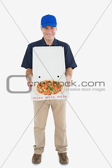 Cheerful delivery man holding pizza