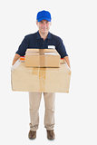 Mature courier man carrying stack of cardboard boxes