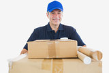 Happy mature courier man carrying cardboard boxes