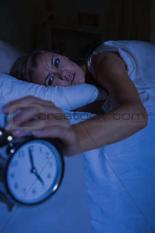 Blonde woman stopping her alarm clock
