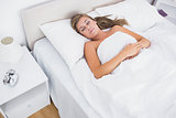 Woman sleeping in white bedroom
