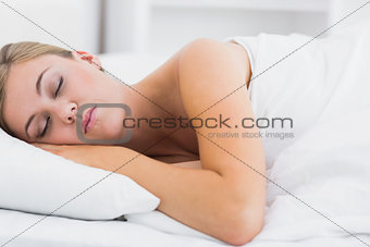 Serene woman sleeping in white bedroom