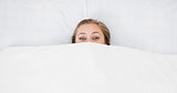 Woman hiding under the duvet