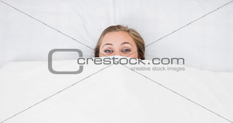 Woman hiding under the duvet