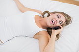 Calm woman phoning lying on the bed